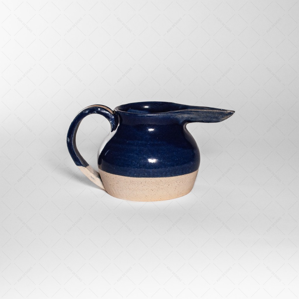A blue pitcher shaped like a stout bird with a round body and long beak.